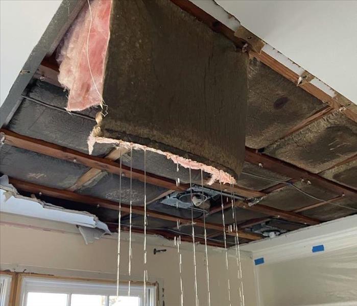 dripping, hanging insulation from damaged ceiling and attic